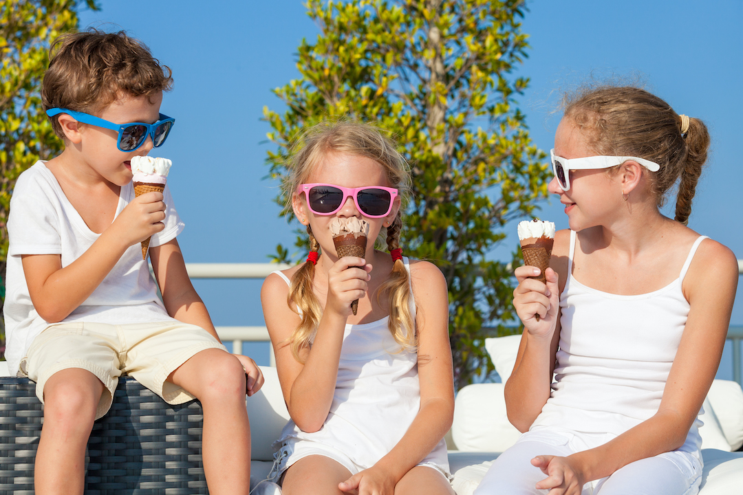 three happy children eating ice cream